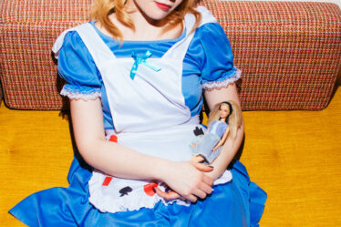 Model with Alice in Wonderland Costume and Barbie in her hands.